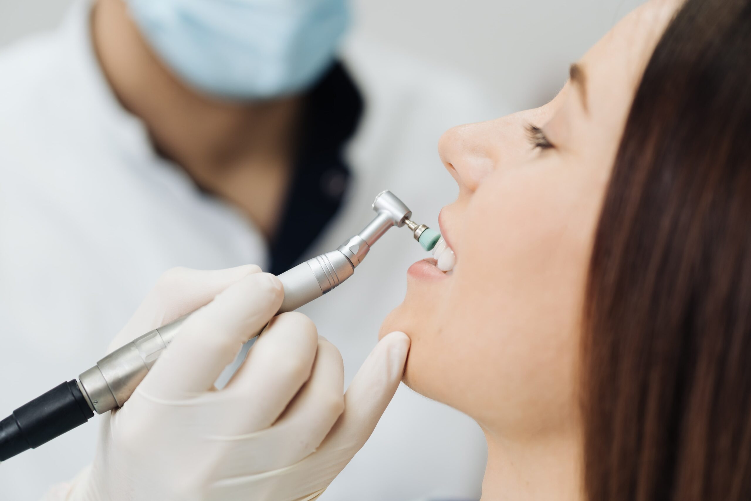 Dentalhygienikerin führt eine gründliche Zahnreinigung bei einem Patienten durch
