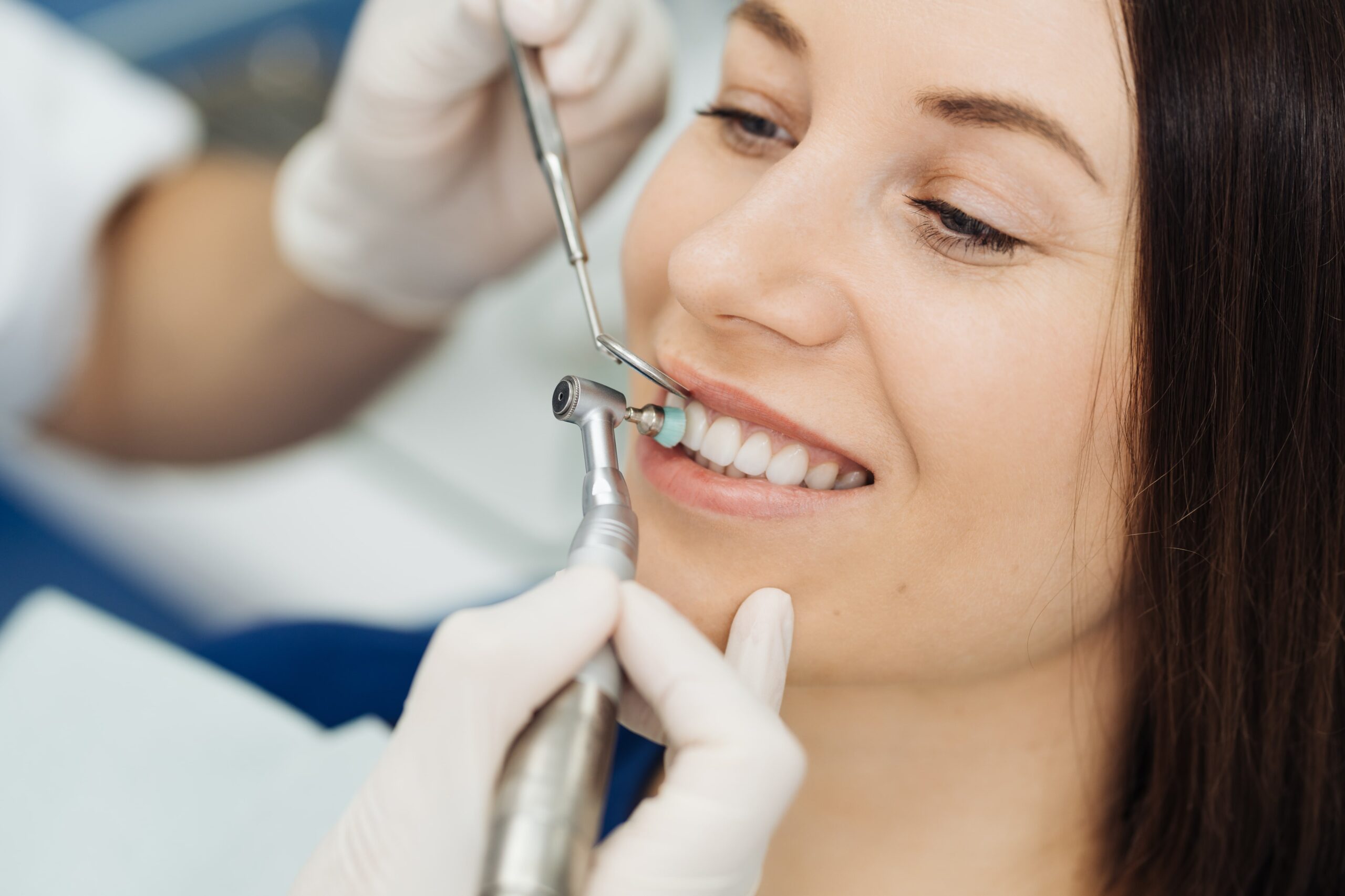 Dentalhygienikerin führt eine gründliche Zahnreinigung bei einem Patienten durch